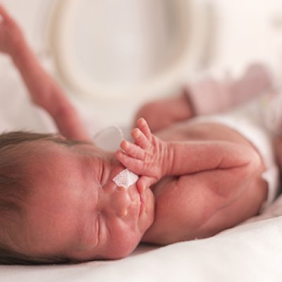 Newborn baby wearing a nappy with hands outstretched  